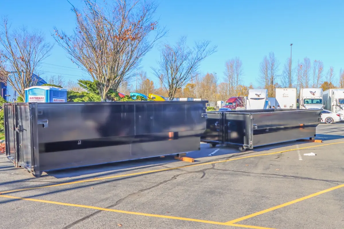 Professional dumpster rental service with roll-off container on residential driveway in Manor